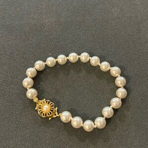 Dainty faux pearl bracelet with ornate floral gold tone clasp